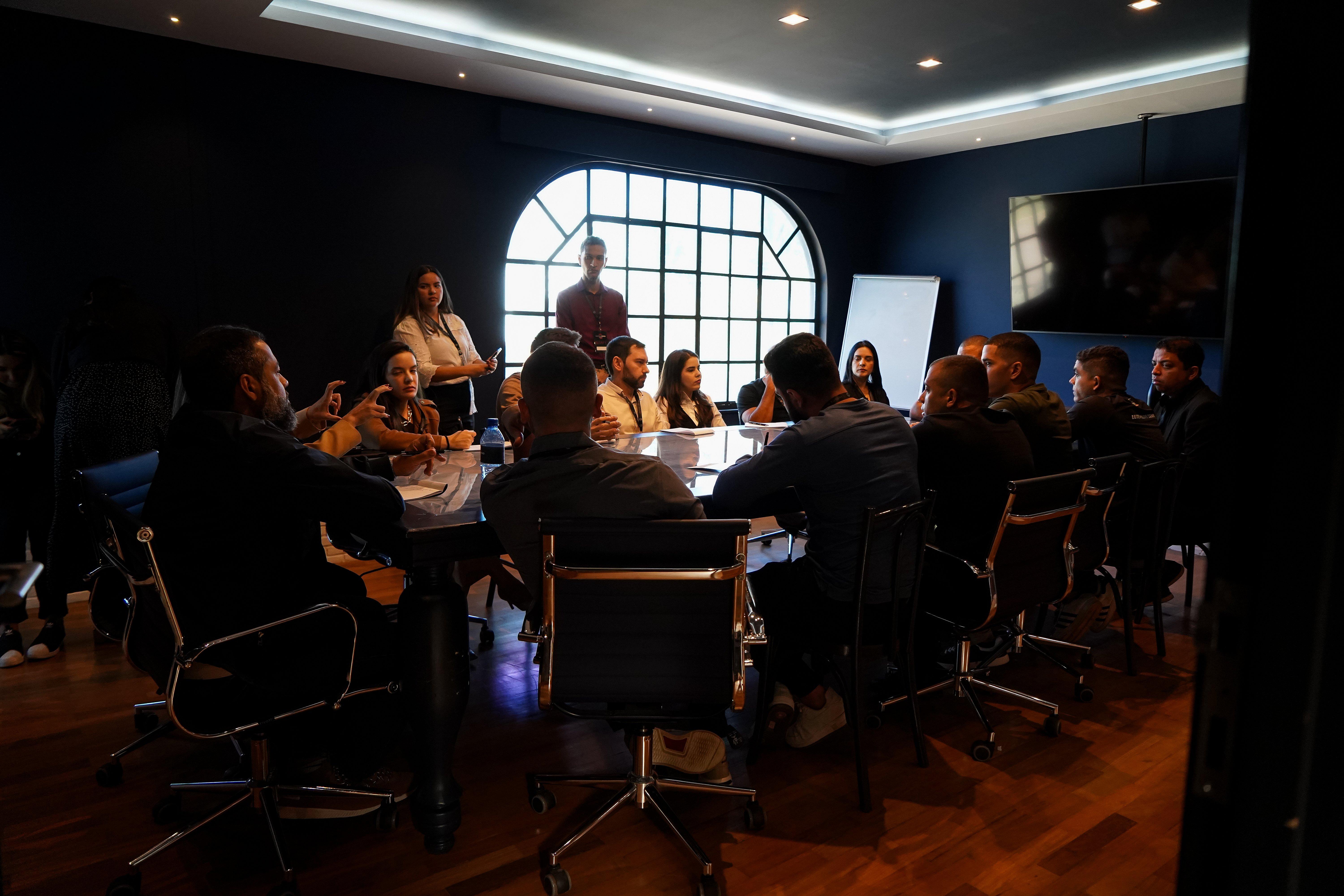 Mesa redonda com participantes na sala de conferencia